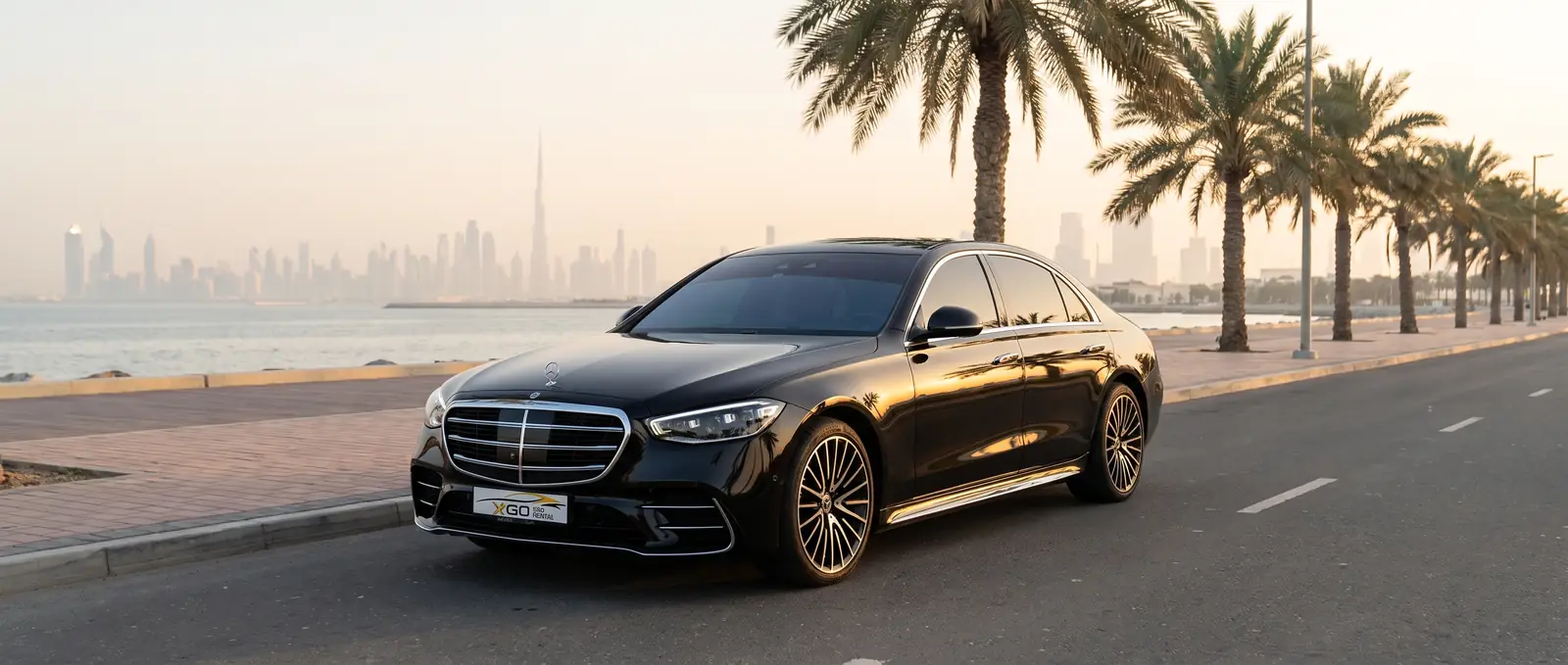 Mercedes-Benz S500 from XGO Car Rental on a Jumeirah seafront road at sunset