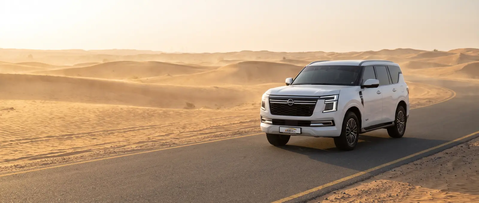 Nissan Patrol 2026 from XGO Car Rental on a desert road outside Dubai at sunrise